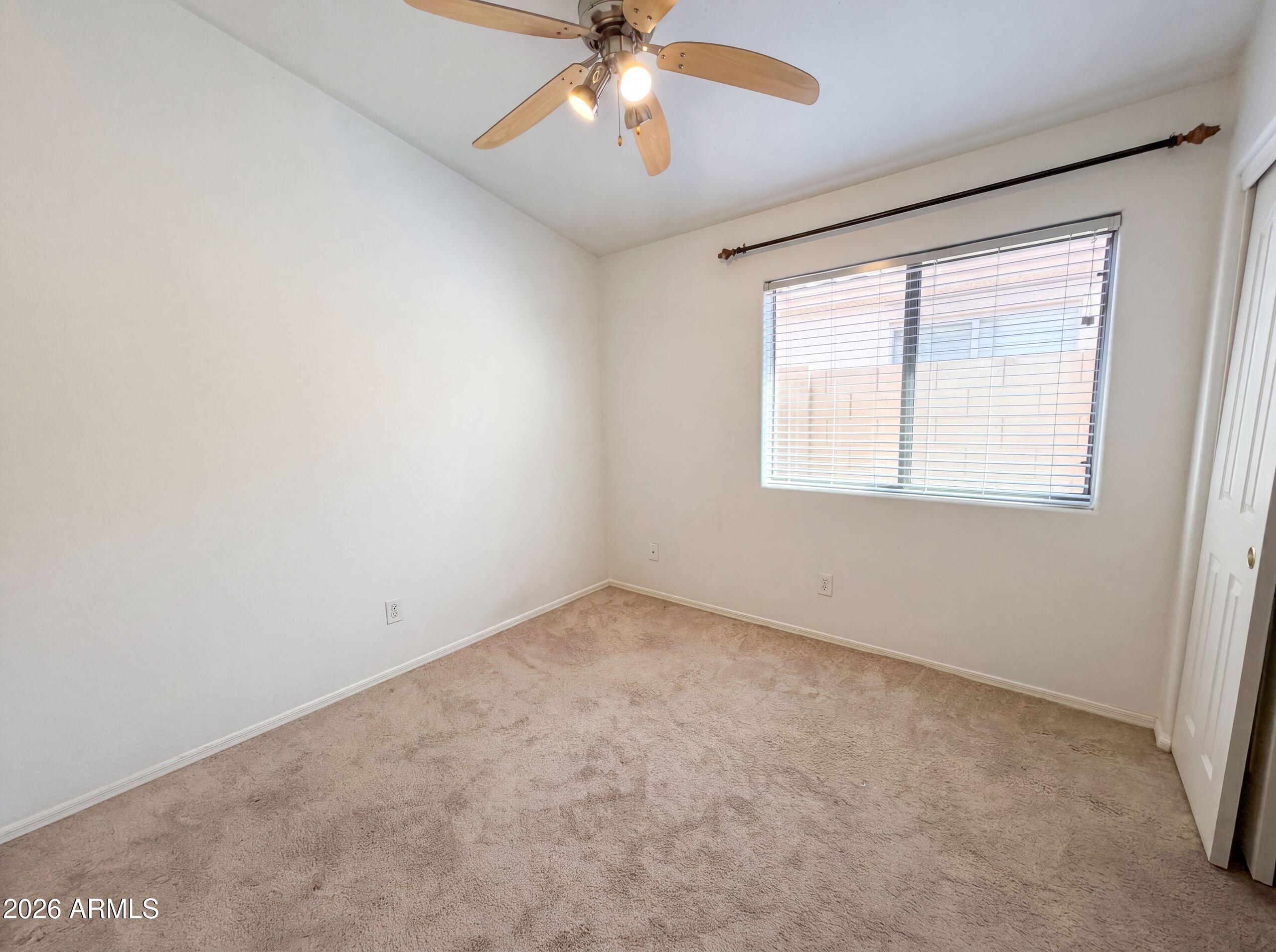 3951 East Timberline Road Gilbert, AZ 85297 - Photo 17 of 28 an empty room with a chandelier fan and windows