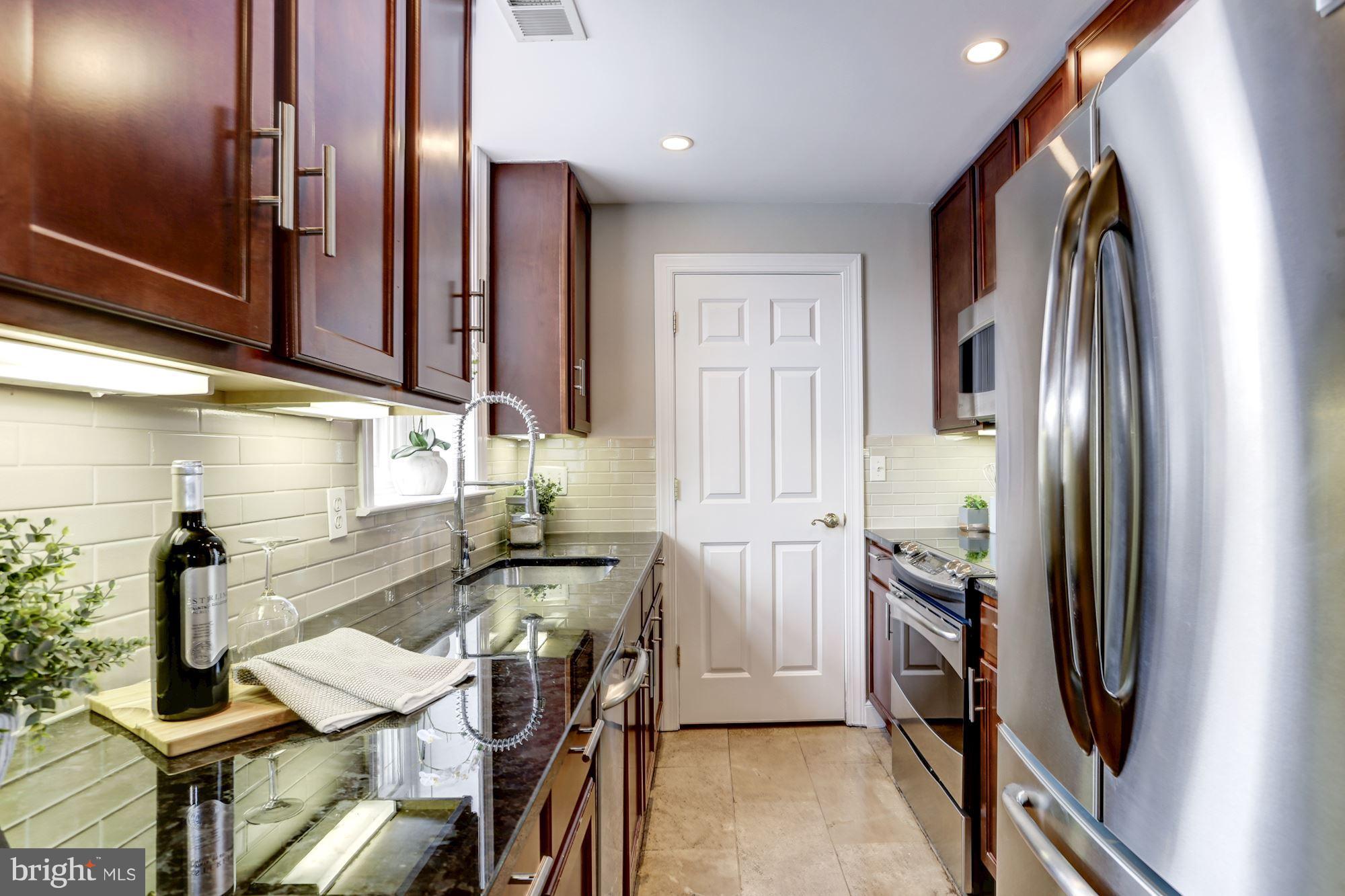 1229 12th Street Northwest, Unit 201 Washington, DC 20005 - Photo 6 of 29 a kitchen with stainless steel appliances granite countertop a refrigerator and a stove