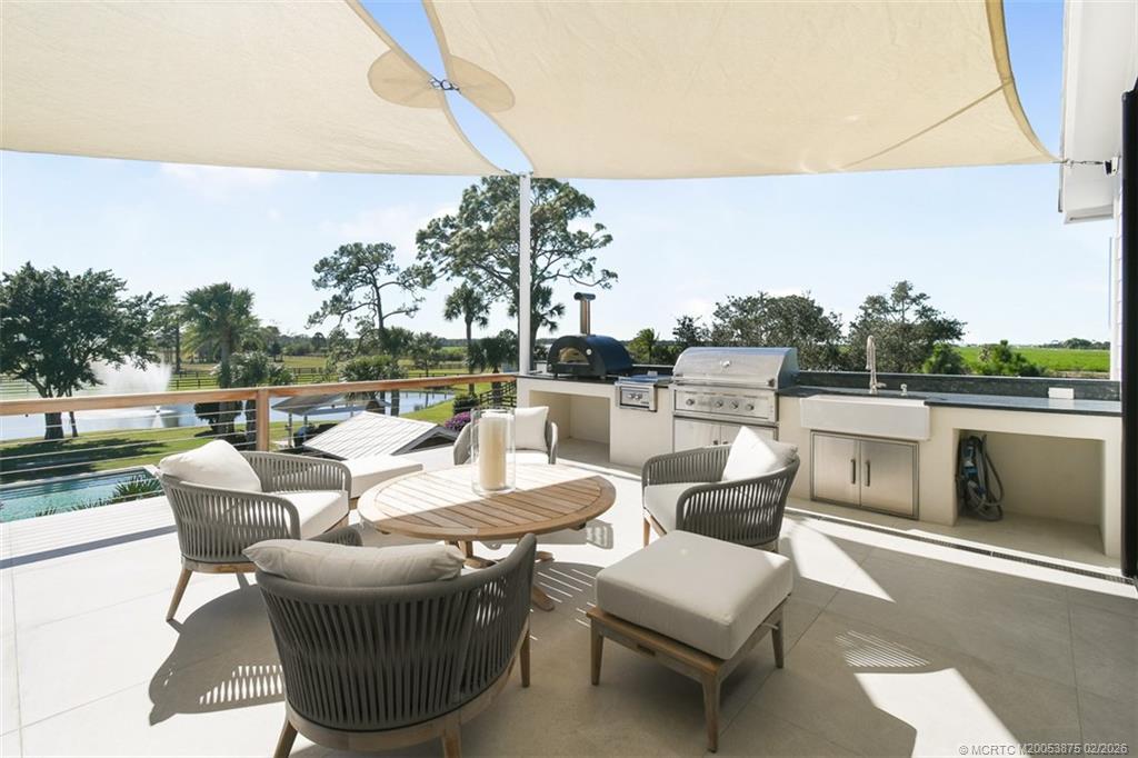 2541 Southwest Trailside Path Stuart, FL 34997 - Photo 38 of 100 a view of a patio with couches chairs dining table and chairs