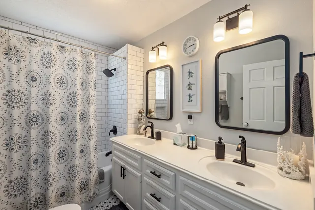 a bathroom with double vanity sink and a mirror