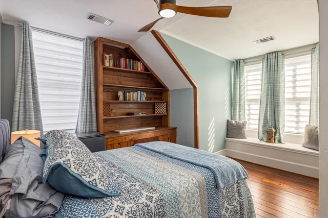 a bedroom with a bed and a large window