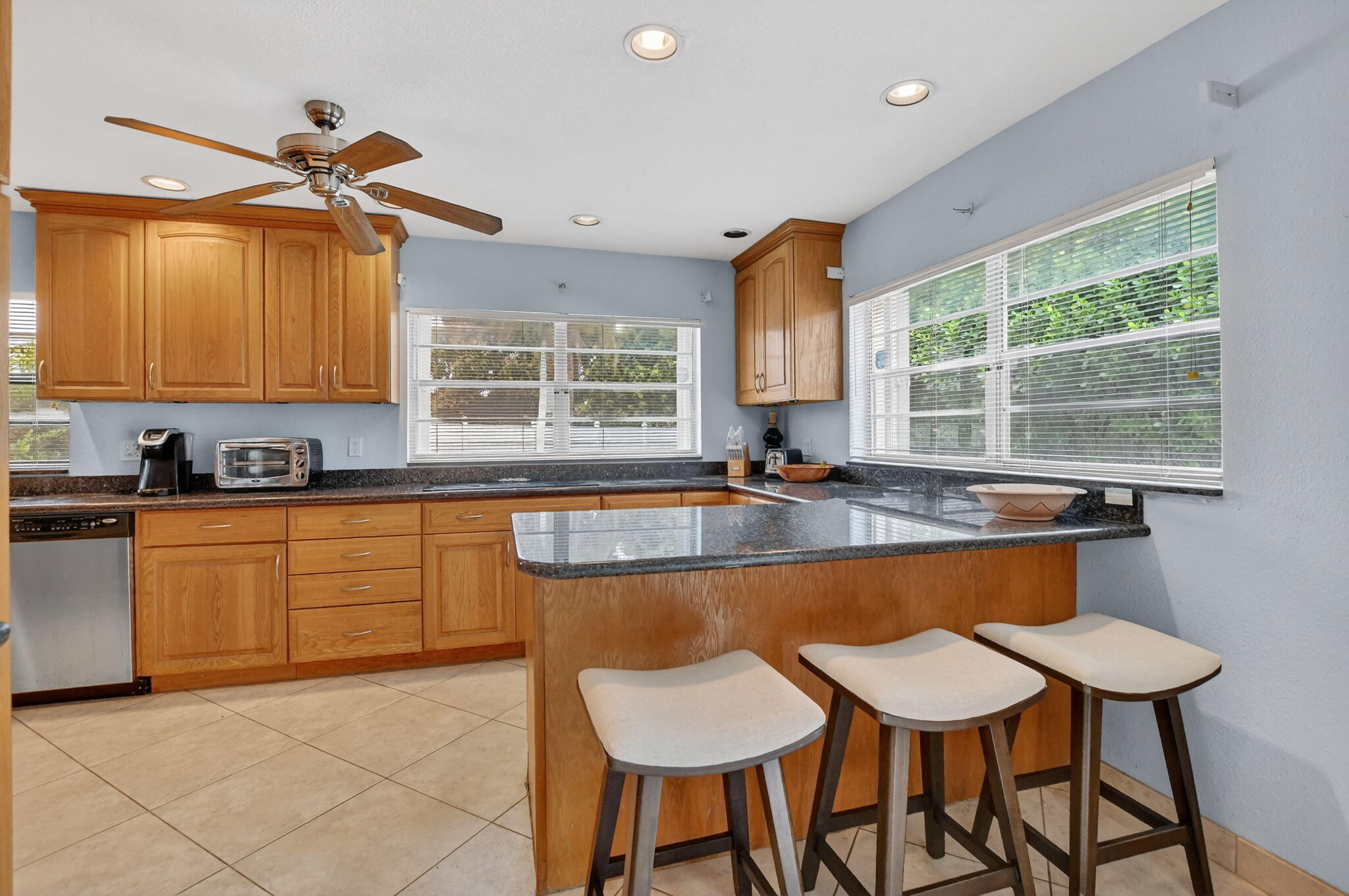 23153 Southwest 60th Way Boca Raton, FL 33428 - Photo 18 of 57 a kitchen with granite countertop a table chairs stove and cabinets