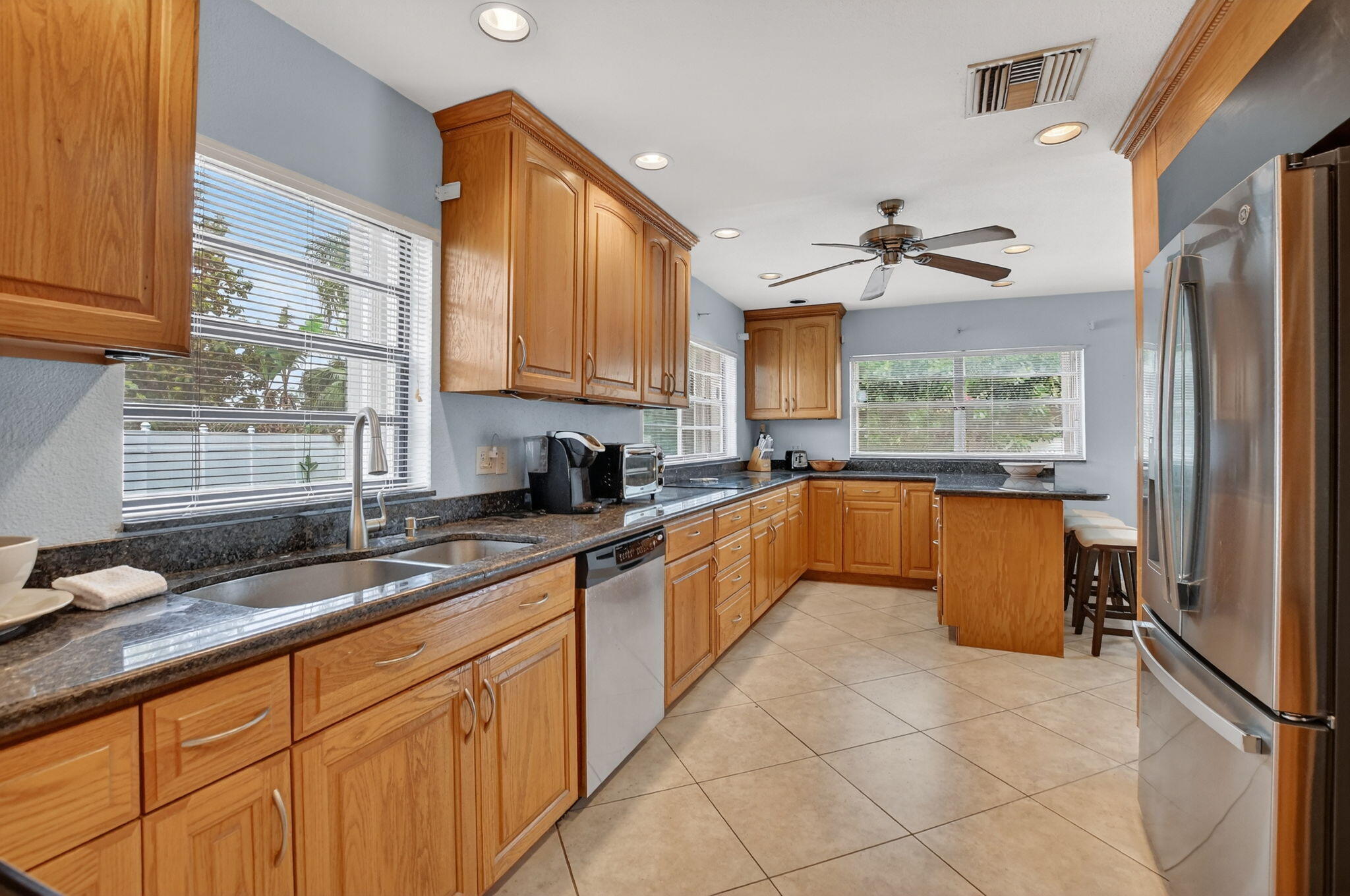 23153 Southwest 60th Way Boca Raton, FL 33428 - Photo 3 of 57 a large kitchen with granite countertop a sink a counter top space appliances and cabinets