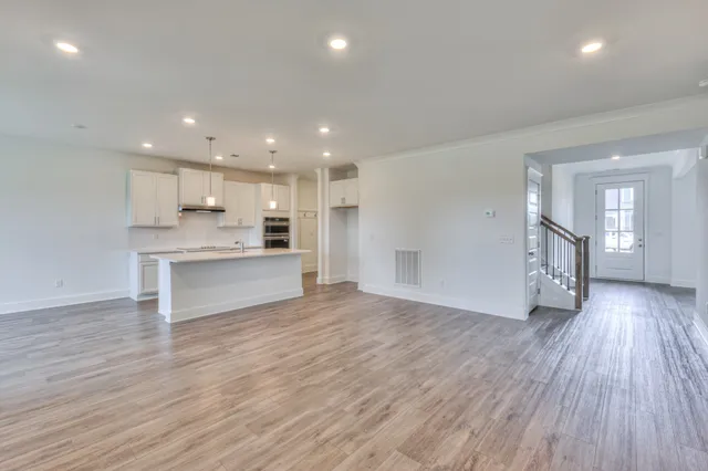 a large kitchen with stainless steel appliances a large counter top a stove and a window