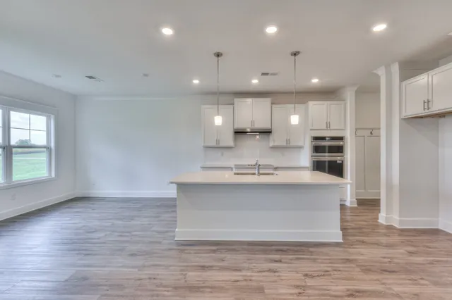 an empty room with windows and fireplace