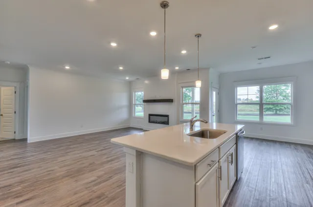 a kitchen with kitchen island a sink stove and wooden floor