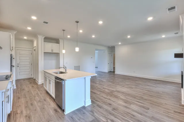 a kitchen with a sink a stove a refrigerator and white cabinets
