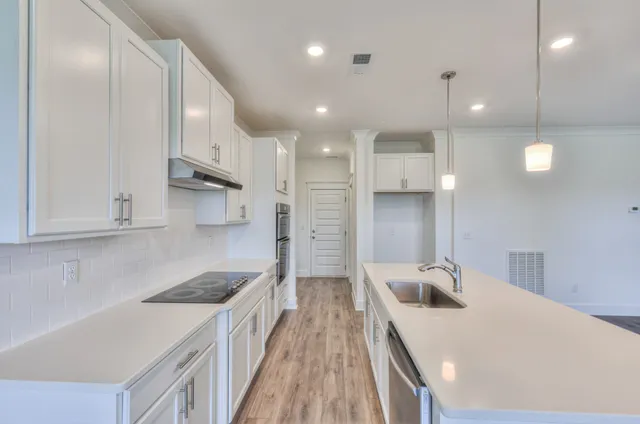 a kitchen with kitchen island a sink stainless steel appliances and cabinets