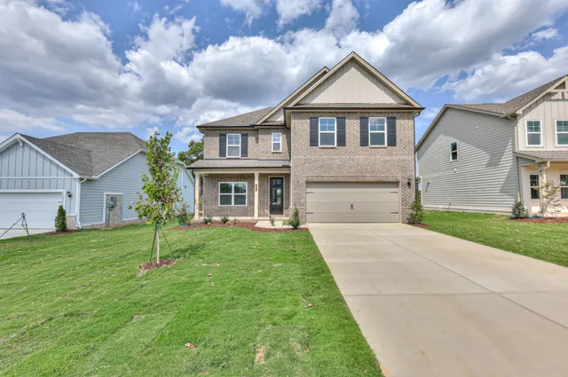 a front view of a house with a yard and garage