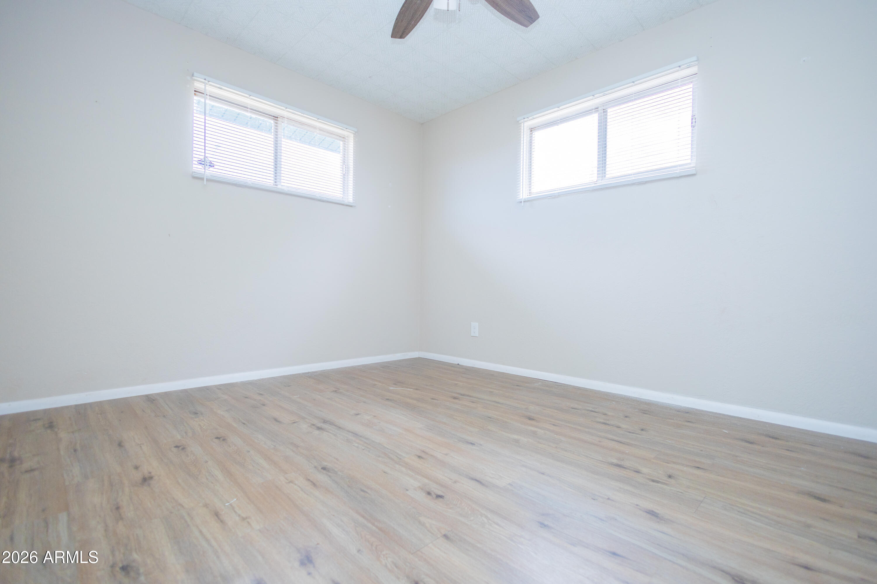 1626 11th Street Douglas, AZ 85607 - Photo 20 of 30 an empty room with wooden floor and windows