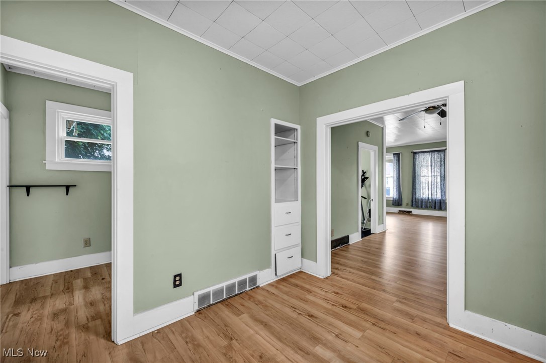 816 Perry Street Sandusky, OH 44870 - Photo 25 of 38 Unfurnished room with ornamental molding, light wood-type flooring, and a ceiling fan