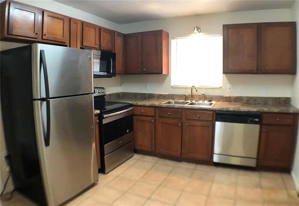 1457 Janmar Drive Decatur, GA 30032 - Photo 2 of 9 a kitchen with stainless steel appliances granite countertop a refrigerator stove a sink and dishwasher