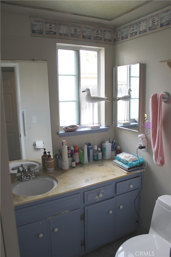 5911 Green Valley Road Riverside, CA 92504 - Photo 12 of 24 a bathroom with a granite countertop toilet sink and mirror
