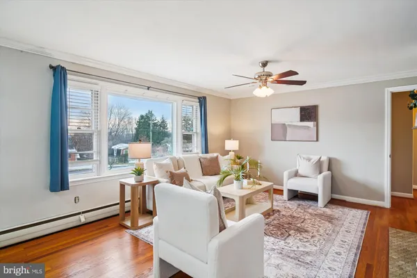 a living room with furniture two window and a ceiling fan