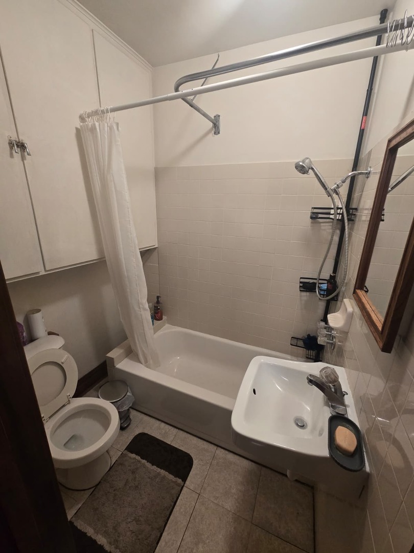 1014 East Prairie Avenue, Unit 2RW Des Plaines, IL 60016 - Photo 2 of 7 a bathroom with a sink a toilet and shower