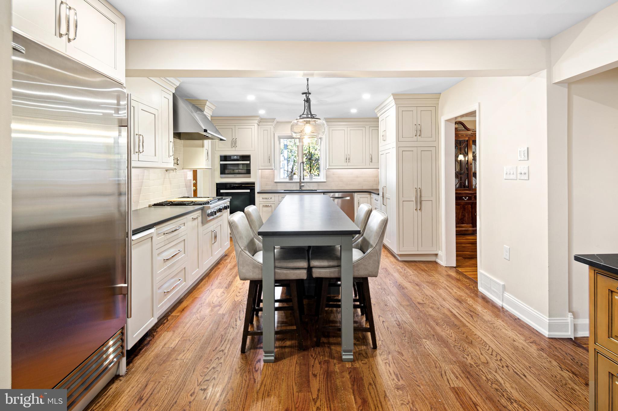 3 Briar Road Wayne, PA 19087 - Photo 10 of 48 a kitchen with stainless steel appliances a refrigerator a stove top oven a sink dishwasher and white cabinets with wooden floor