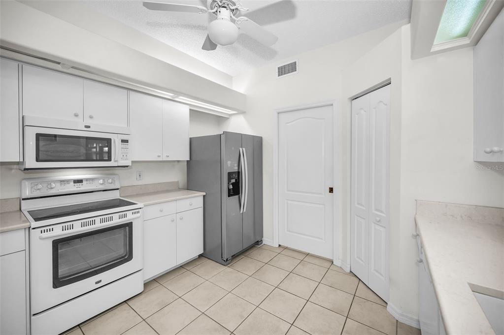 271 Hemingway Drive Oldsmar, FL 34677 - Photo 11 of 31 a kitchen with stainless steel appliances a stove a microwave and white cabinets