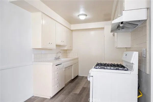 a kitchen with stainless steel appliances granite countertop a sink stove and white cabinets