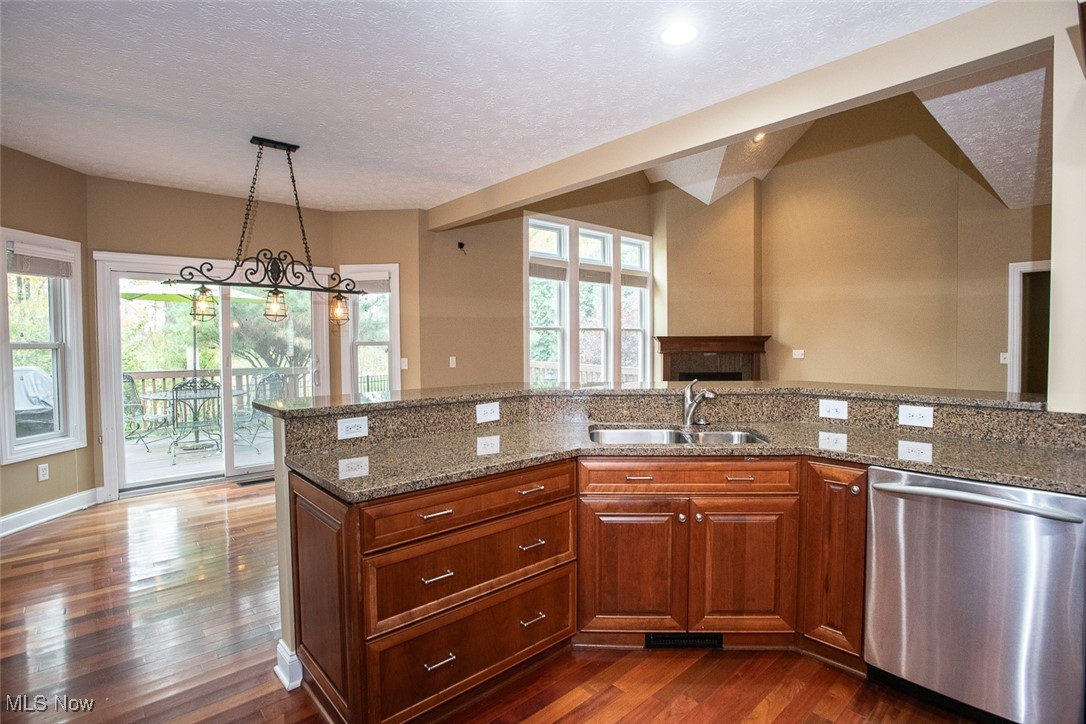 630 Rundle Street Lagrange, OH 44050 - Photo 15 of 49 Kitchen featuring stainless steel dishwasher, dark stone countertops, a textured ceiling, dark wood-type flooring, and decorative light fixtures