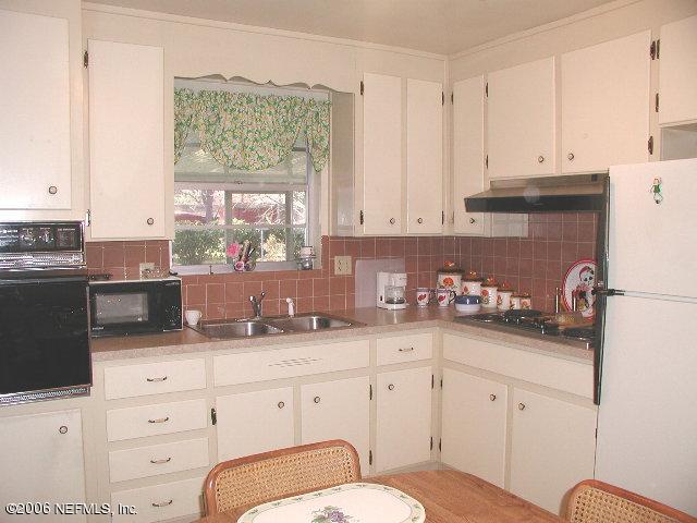 2704 Sam Road Jacksonville, FL 32216 - Photo 5 of 9 a kitchen with granite countertop white cabinets and white appliances