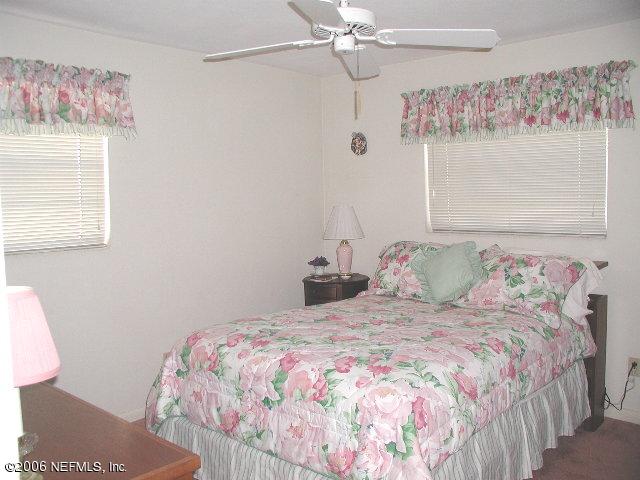 2704 Sam Road Jacksonville, FL 32216 - Photo 7 of 9 a bedroom with a bed and a chandelier