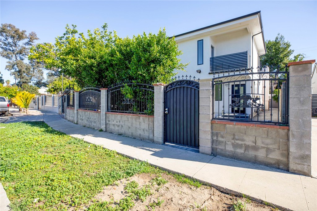 a view of a house with a small yard and wooden fence