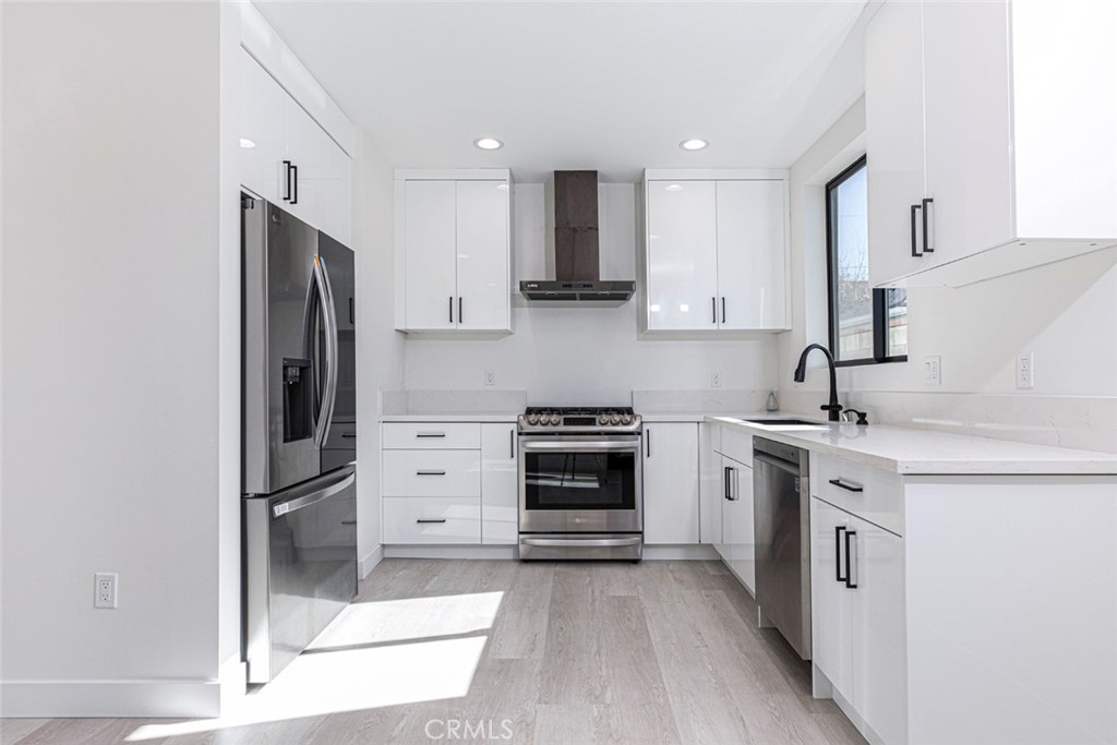 7446 Mammoth Avenue Van Nuys, CA 91405 - Photo 7 of 30 a kitchen with stainless steel appliances granite countertop a stove and a refrigerator