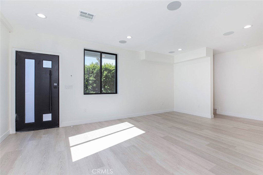 7446 Mammoth Avenue Van Nuys, CA 91405 - Photo 10 of 30 an empty room with wooden floor and windows