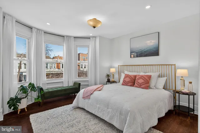 a bedroom with a bed and a potted plant
