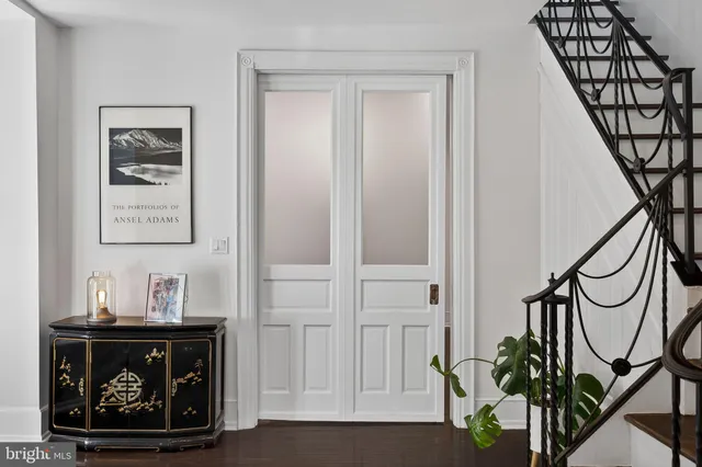 a room with painting on the wall and a potted plant