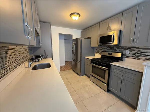 a kitchen with stainless steel appliances a stove sink microwave and cabinets