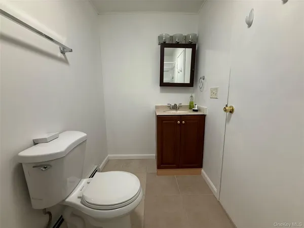 a bathroom with a toilet a sink and mirror
