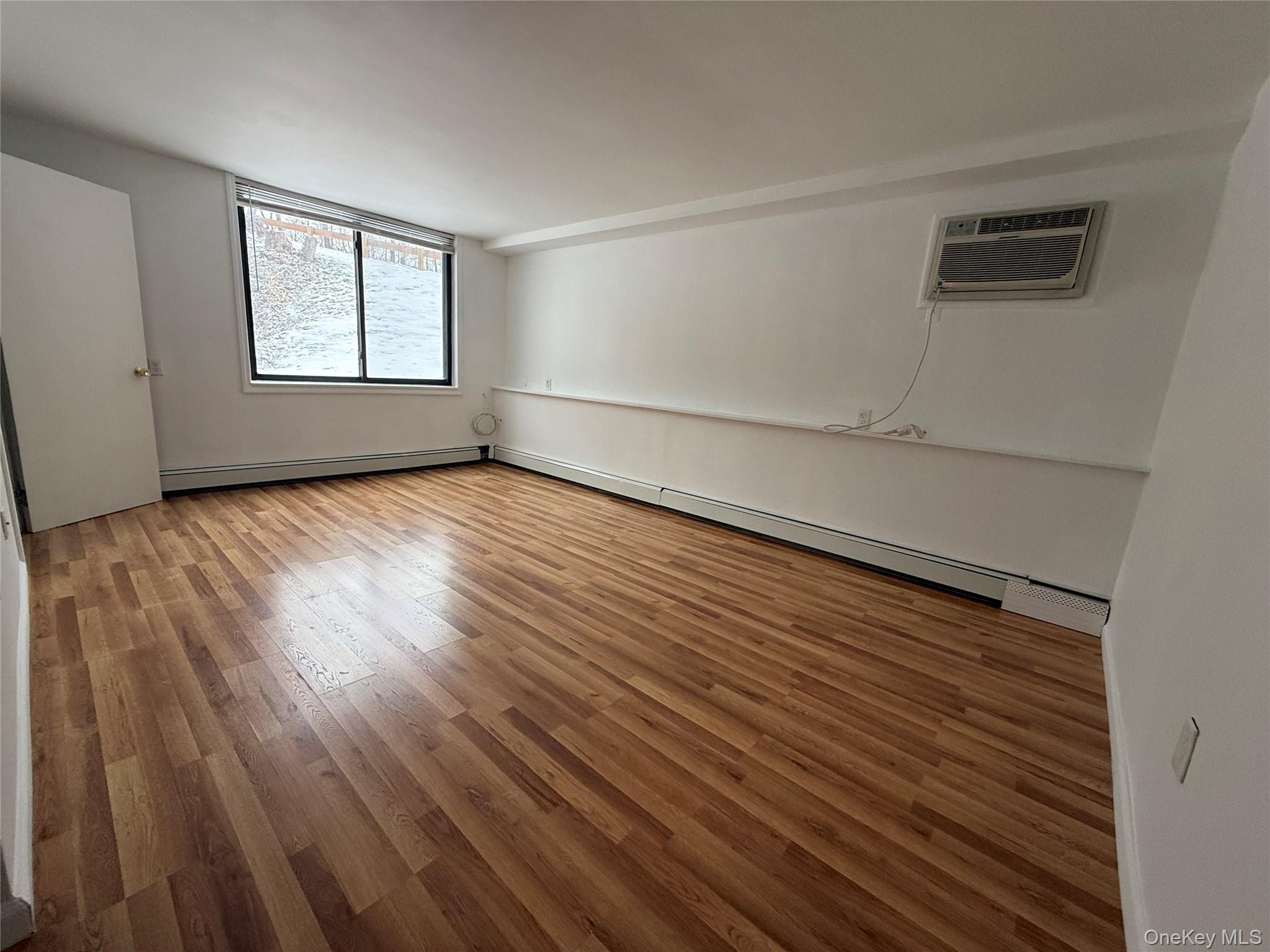 3 Hook Road, Unit 33B Poughkeepsie, NY 12601 - Photo 6 of 9 an empty room with wooden floor and windows