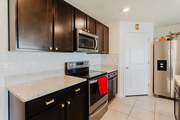 a kitchen with kitchen island granite countertop a sink and a stove top oven