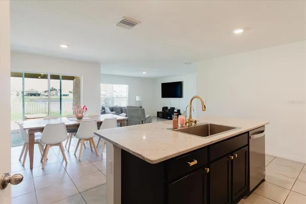 a view of living room with granite countertop a couch and a flat screen tv