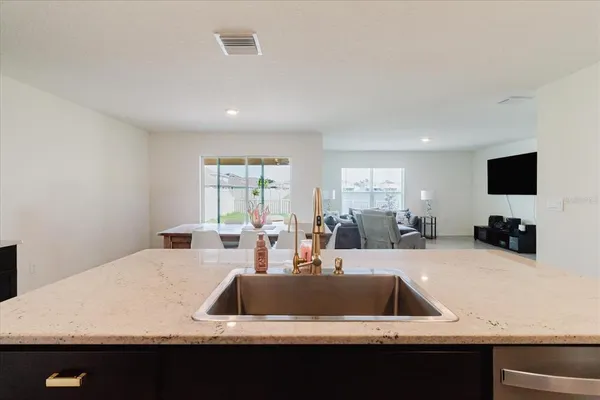 a large kitchen with stainless steel appliances a refrigerator sink a stove a microwave and a refrigerator