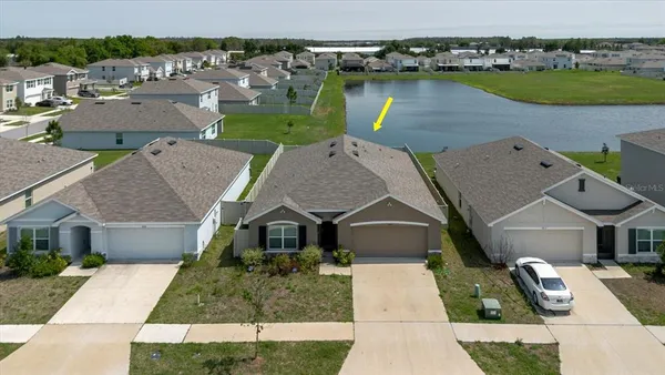 an aerial view of a house with garden space and lake view