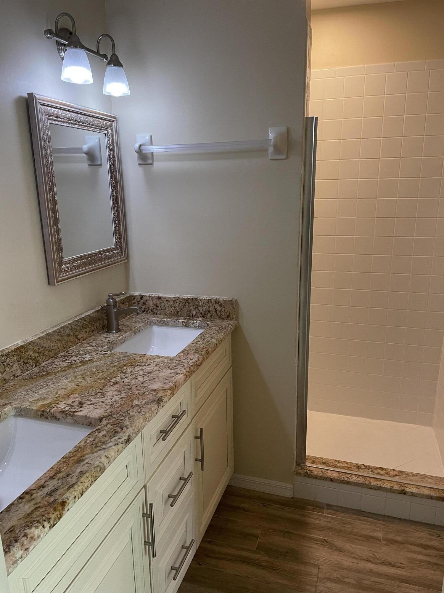1024 Mainsail, Unit 514 Naples, FL 34114 - Photo 12 of 18 a bathroom with a granite countertop sink and a mirror