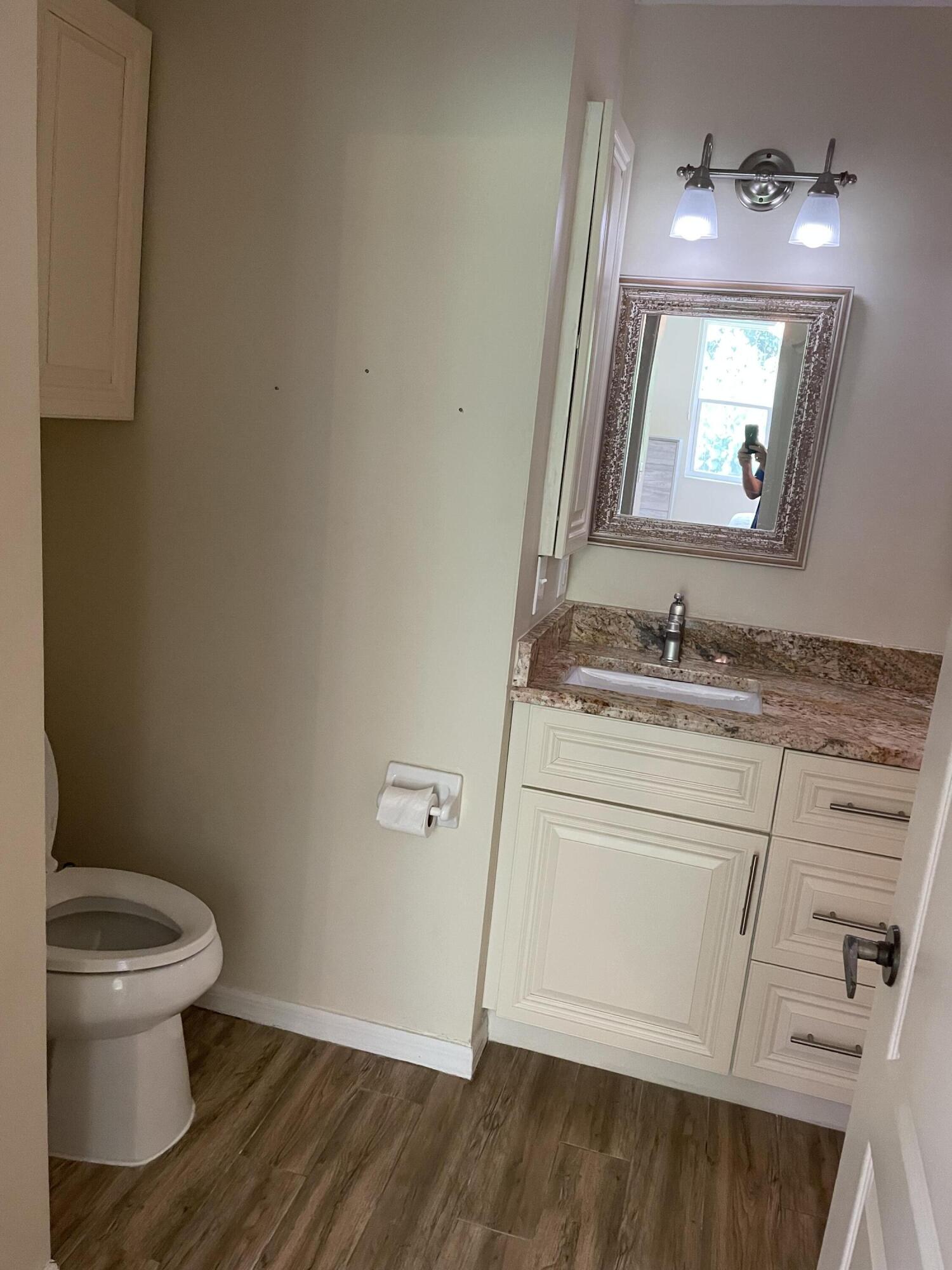 1024 Mainsail, Unit 514 Naples, FL 34114 - Photo 13 of 18 a bathroom with a granite countertop toilet sink and mirror