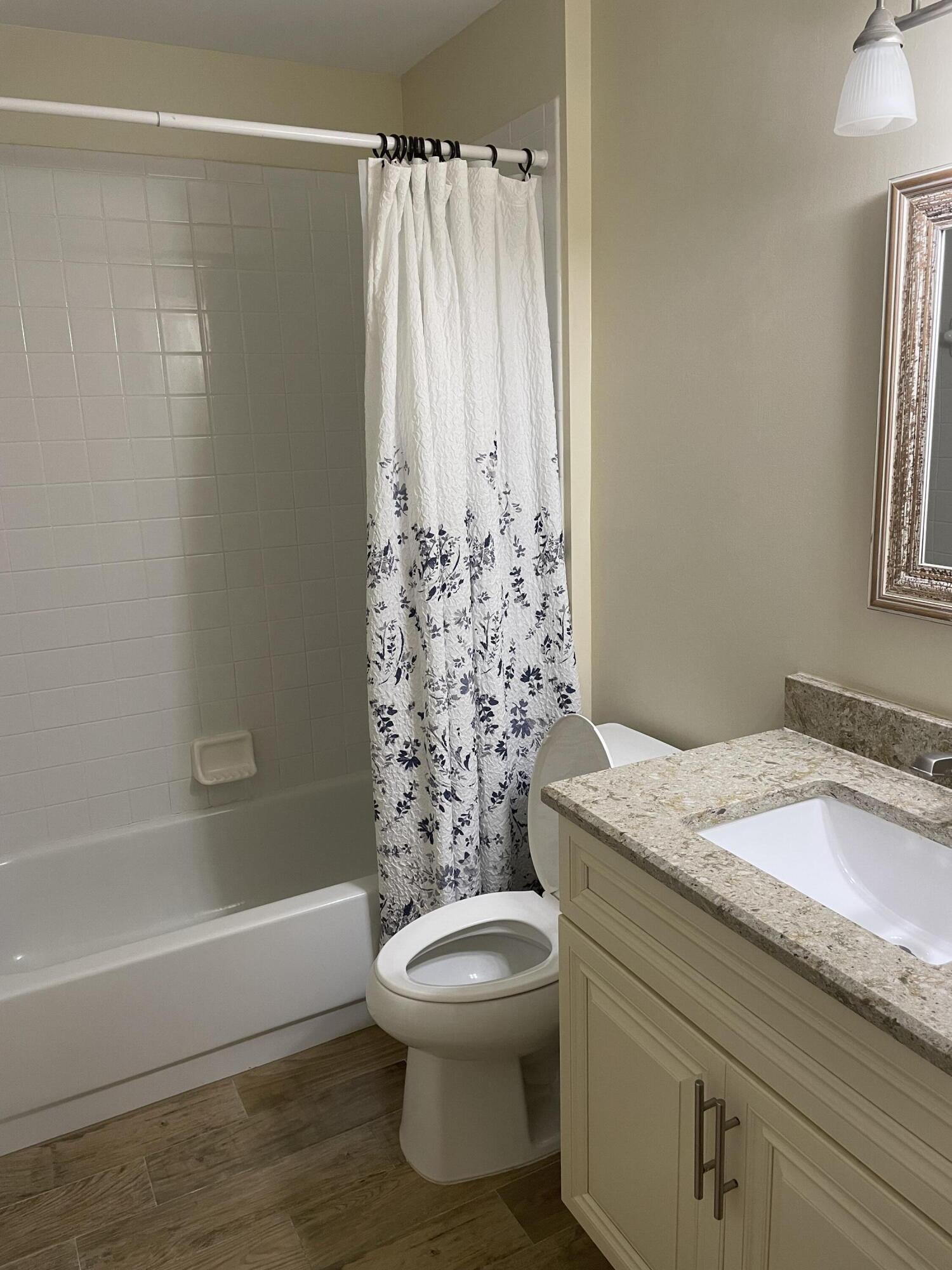 1024 Mainsail, Unit 514 Naples, FL 34114 - Photo 16 of 18 a bathroom with a granite countertop sink toilet and shower