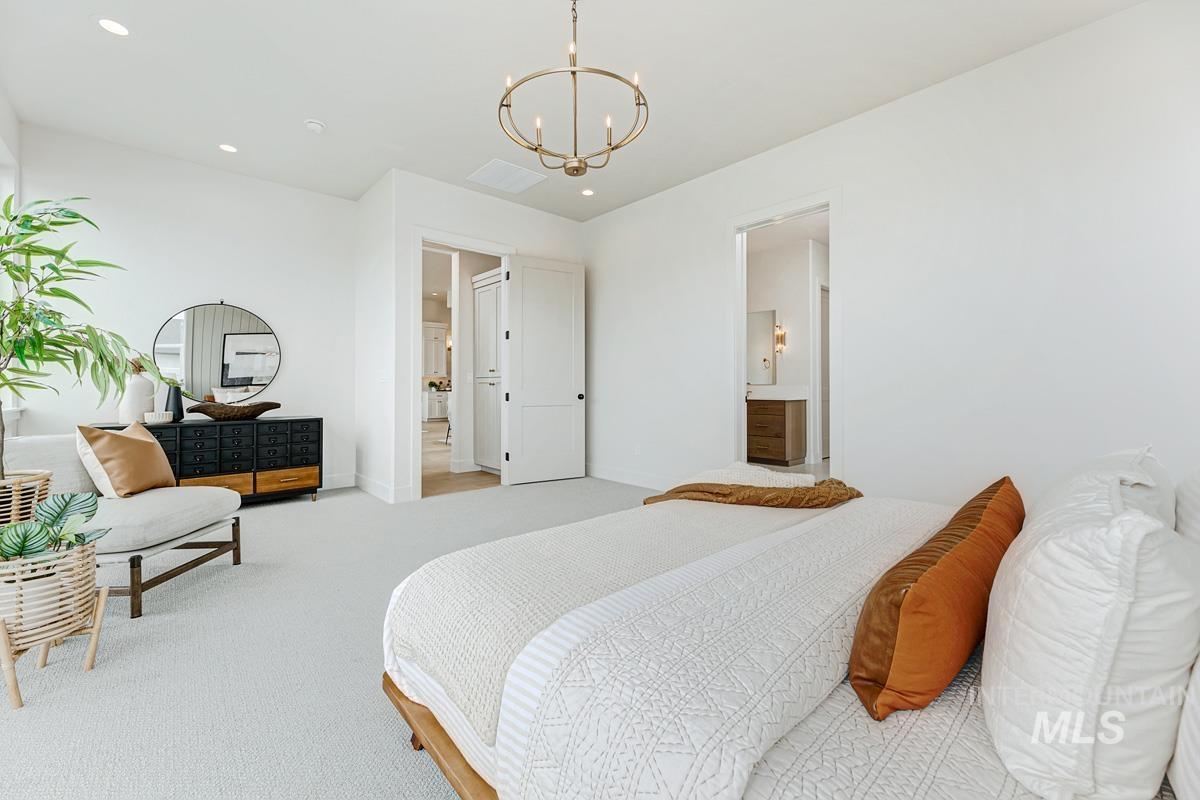 13758 North Ruffed Grouse Way Boise, ID 83714 - Photo 18 of 45 Carpeted bedroom with hanging lights and ensuite bathroom