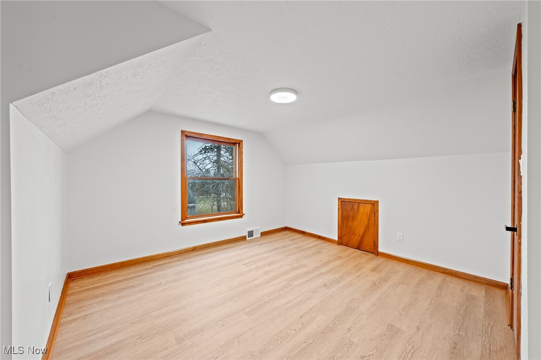 5266 Wilson Mills Road Cleveland, OH 44143 - Photo 28 of 50 Additional living space featuring wood finished floors, a textured ceiling, and vaulted ceiling