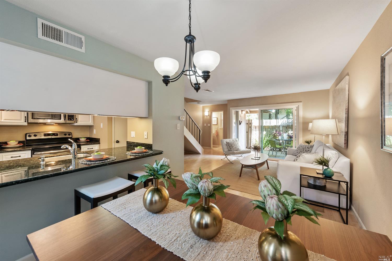 a view of a dining room with furniture a chandelier and wooden floor