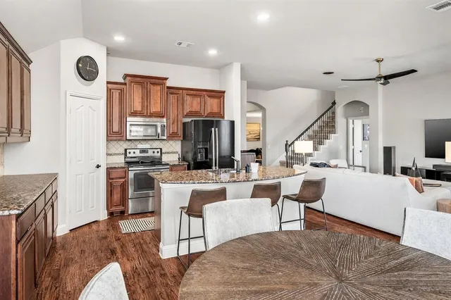 a spacious bedroom with a large bed and a chandelier fan