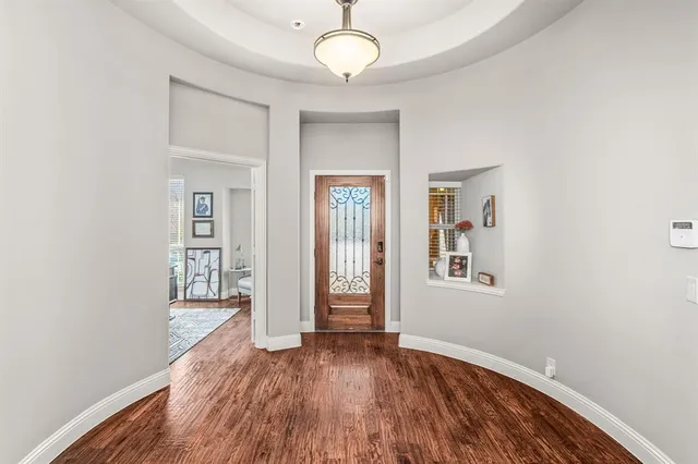 a view of a hallway with wooden floor and a living room