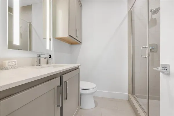 a bathroom with a sink a toilet and shower