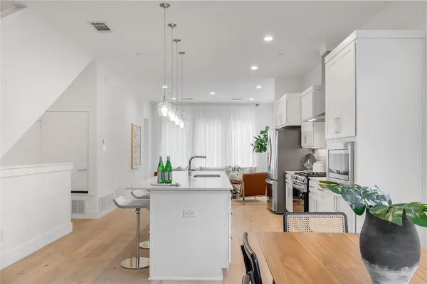 a living room with furniture a potted plant and a kitchen view