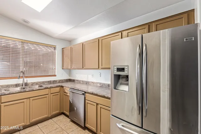a kitchen with stainless steel appliances granite countertop a refrigerator and a sink
