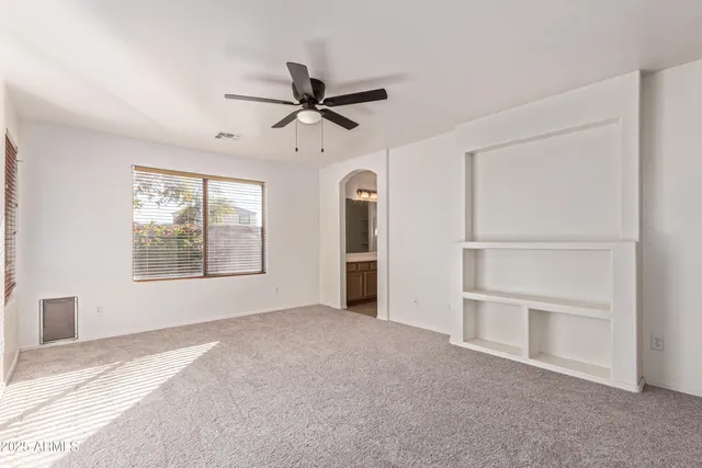a view of a livingroom with a ceiling fan and window