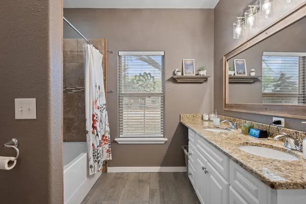 a bathroom with a granite countertop sink a toilet and a mirror